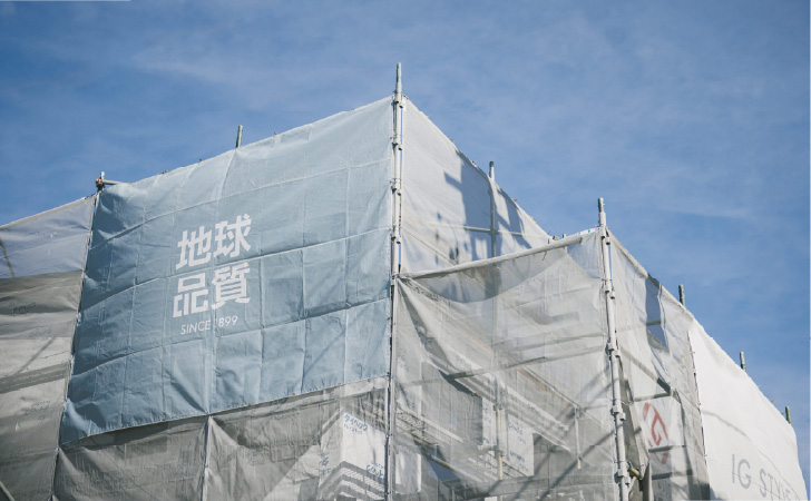 足場と養生シートを設置した工事中の建物